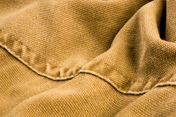 clothing items stonewashed cotton fabric texture with seams, clasps, buttons and rivets, macro