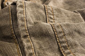 clothing items stonewashed cotton fabric texture with seams, clasps, buttons and rivets, macro