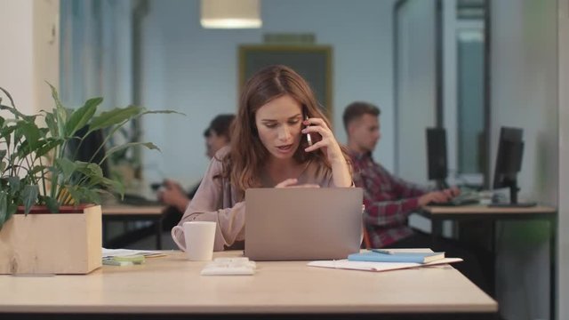 Business woman screaming in mobile phone. Upset woman throwing mobile phone