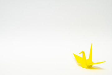 yellow origami paper crane on white background