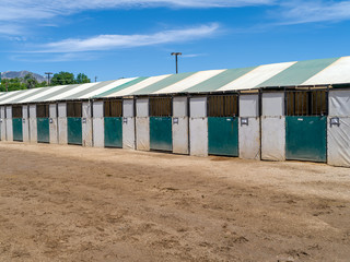 Row of temporary horse stalls with a blue sky.