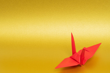 red origami paper crane on golden background