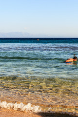 Fototapeta na wymiar A child enjoying snorkeling in the clear sea.