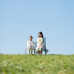 草原で椅子に座る親子