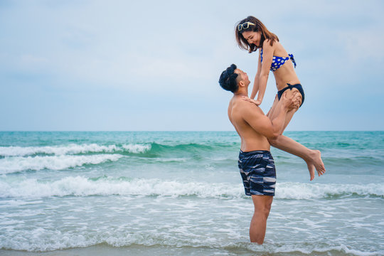 couple having fun and ramance moment playing together on beach