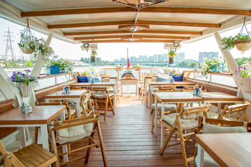 The interior of the urban river ship, with a panoramic view of the urban landscape. The concept of tourism, recreation, walking around the city, rest in the city. River transport.