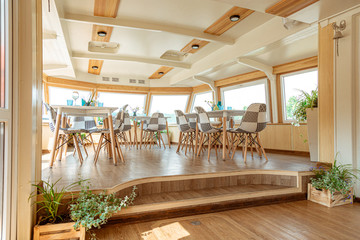 The interior of the urban river ship, with a panoramic view of the urban landscape. The concept of tourism, recreation, walking around the city, rest in the city. River transport.