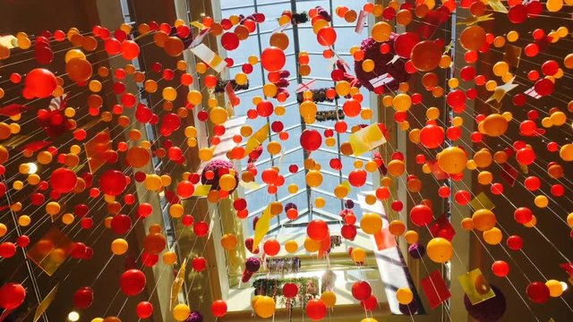 Hanging decotation from plastic balls and plates moving shining on sun