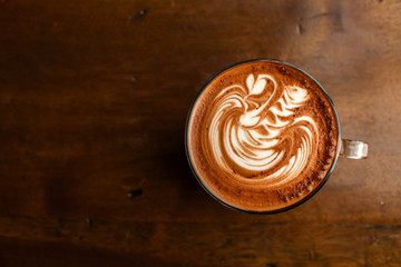 Hot latte art coffee top view on wood table