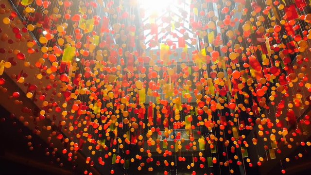 Hanging decotation from plastic balls and plates moving shining on sun