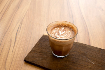 Hot latte and beautiful art latte on wooden floors