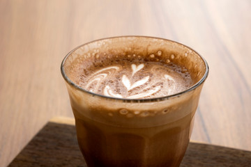 Hot latte and beautiful art latte on wooden floors