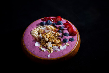 Smoothie bowl with fruits in wooden bowl