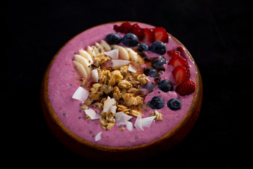 Smoothie bowl with fruits in wooden bowl