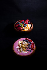 Smoothie bowl with fruits in wooden bowl