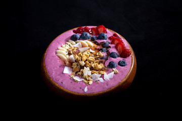 Smoothie bowl with fruits in wooden bowl