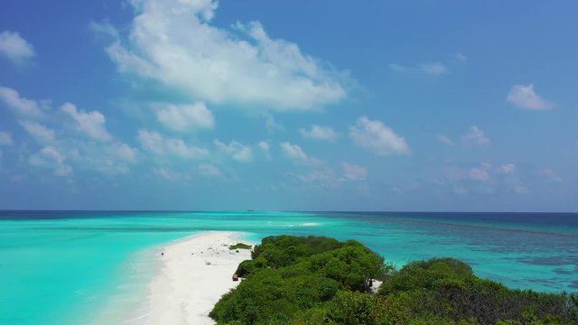 Flight down onto an exotic island with trees and sand on it. The turquoise sea around. Blue sky with clouds. Indonesia. Pedestal down