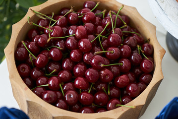 Fresh cherries in wooden bowl on table, close-up. Red cherry berries