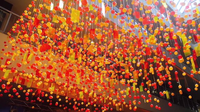 Hanging decotation from plastic balls and plates moving shining on sun