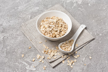 Oat flakes in white bowl for healthy breakfast