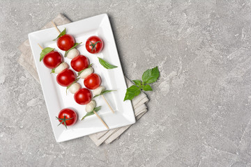 Italian Caprese salad with mozzarella cheese, Cherry tomatoes and basil on skewers