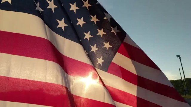 Slow Motion American Flag waving in the golden light of sunrise, fourth of July, Patriotism