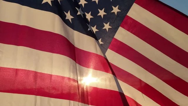 Slow Motion American Flag waving in the golden light of sunrise, fourth of July, Patriotism