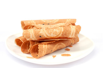 Crispy golden curl or Thai people call Thong Muan is a snack in white plate isolated on white background.