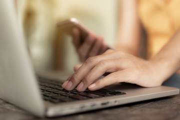Working woman is working with a smart phone and computer. The concept of women working with technology.