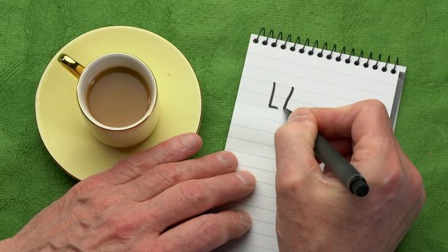 Lagom, not too little, not too much, just right - Swedish philosophy for a balanced life - man hand writing in a notebook, overhead view