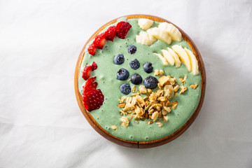 Spirulina yogurt with fruit in wooden bowl