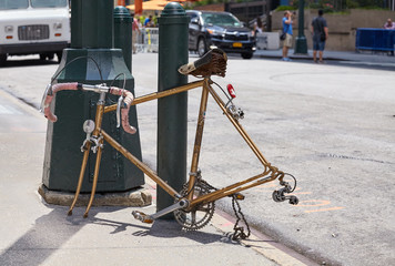 An old broken racing bicycle without wheels on a street of Manhattan, New York, USA.