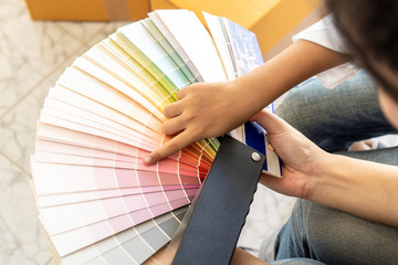 close up hands of a girls choosing colorful samples or paint colour from swatch, new home or new room or bedroom. renovation or cooperation, team, interior and people concept