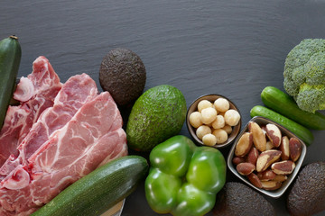 Keto diet. Avocado, zucchini, cucumbers, cheese, meat, nuts on a black slate background.set of products for low carb keto ketogenic diet.Top view,copy space.