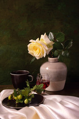Still life with white rose and green gooseberries on the branch.
