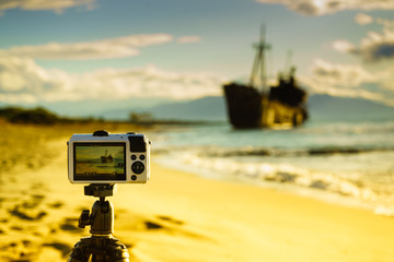 Camera on tripod and shipwreck