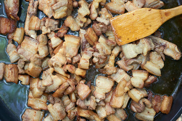 Slices of bacon on a hot cast-iron pan. Cooking in the campaign at the stake.