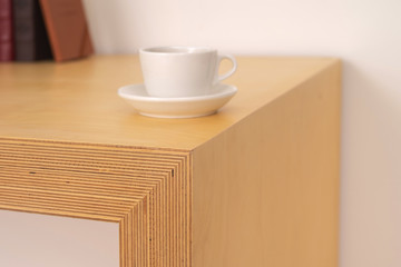 a cup of coffee at the corner of a wooden desk