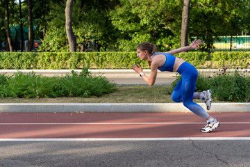 girl at start of running track. Running on cross. Sports start. girl in pose on the starting line...