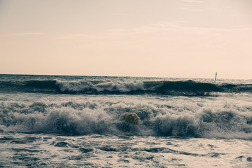 Naklejka na ściany i meble Buoy in the sea waves with foam. Empty beach. Summer vacations travel. Stormy ocean.