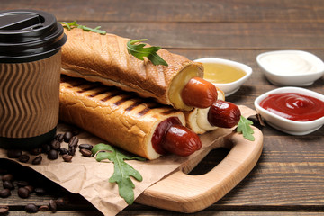 French hot dogs. Tasty hot dogs on the board and coffee on a brown wooden table. fast food street...