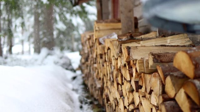Freshly stacked firewood awaits its use in winter ski lodge under fresh snow
