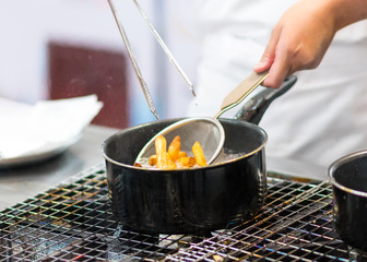 Chef is cooking french fries in the kitchen, Chef cooking fried potato in pan