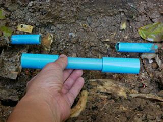 Selective focus of broken / leaked / cracked PVC water pipe underground is about to be fixed by replacing the cut-off part with new pipes