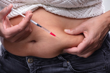 Obraz na płótnie Canvas Diabetic Woman Injecting On Stomach
