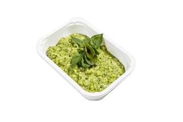 Isolated green puree with green leafs on it in white plastic container on white background.