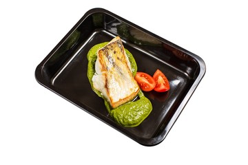 Isolated dish of cooked sea fish with pesto and tomato sliced in black container. Asian seafood concept.