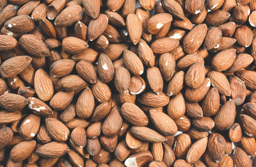 Almond nuts lying on white background. Healthy food. Vegan concept. Lifestyle. Vertical.