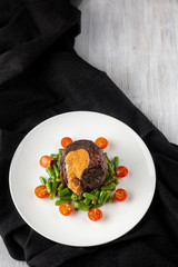 Medium rare mignon fillet roasted with green beans and fresh cherry tomatoes, decorated with creamy sauce for a healthy dinner in a restaurant