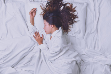 Young Woman Sleeping In Bed. Top view of young woman lying down sleeping well in bed. sleeping relax, young smiling pretty lady lies in bed. relaxing, sleeping.